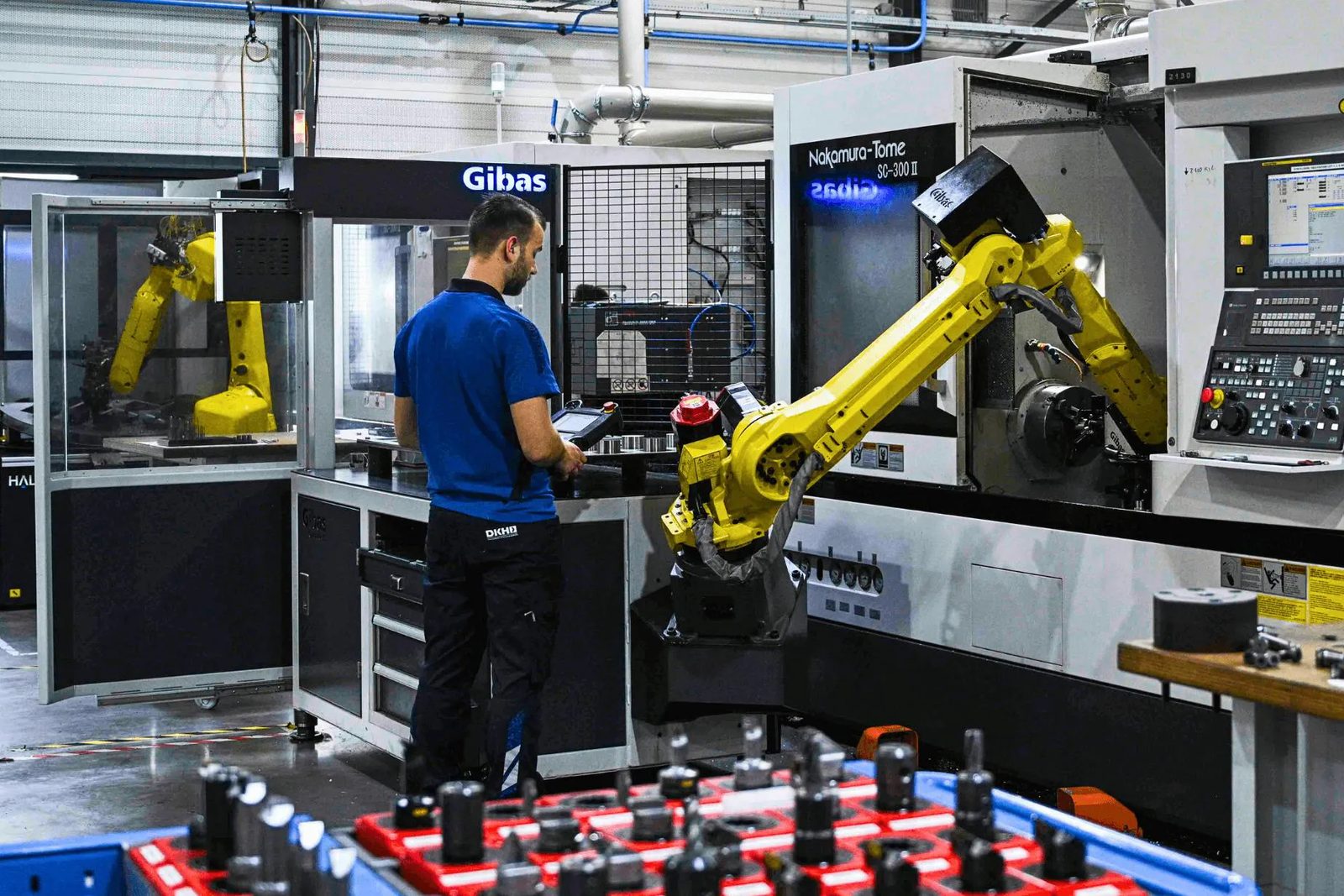 Robotarm en operator in de productiehal van Andra Tech Group
